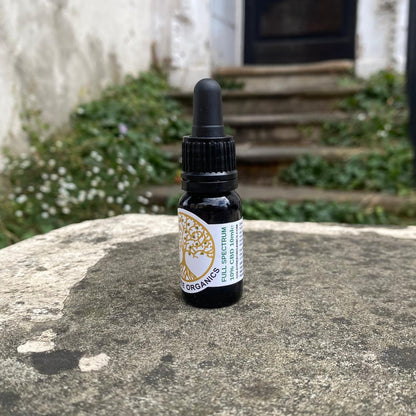 Bottle of organic spectrum oil on a stone surface with a garden background